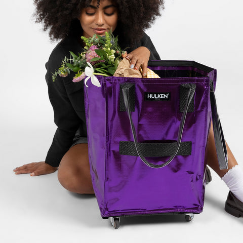 A lady with a purple tote bag and flowers