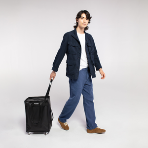 Person holding a black Travel Rolling Tote