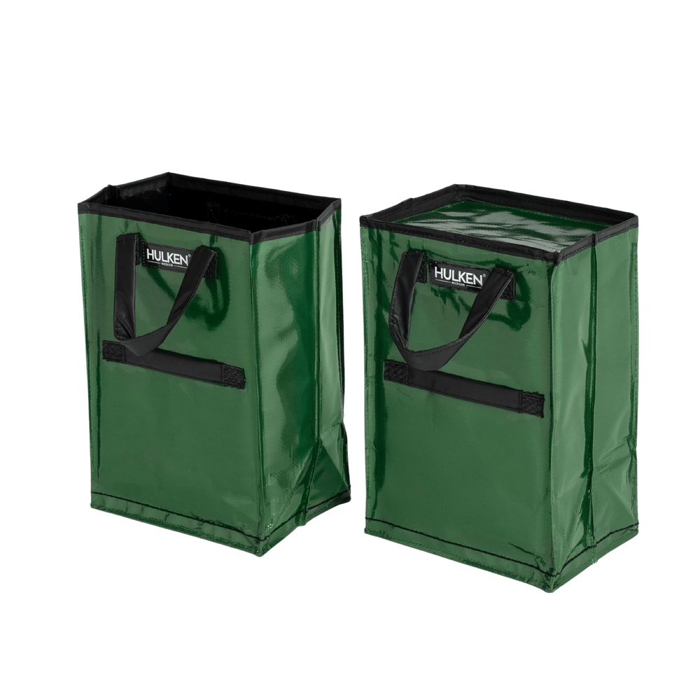 Two green storage bags with black handles on a transparent background