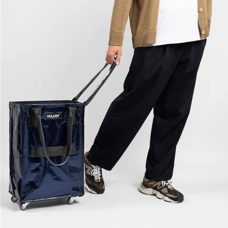 Person walking with a small midnight blue tote bag