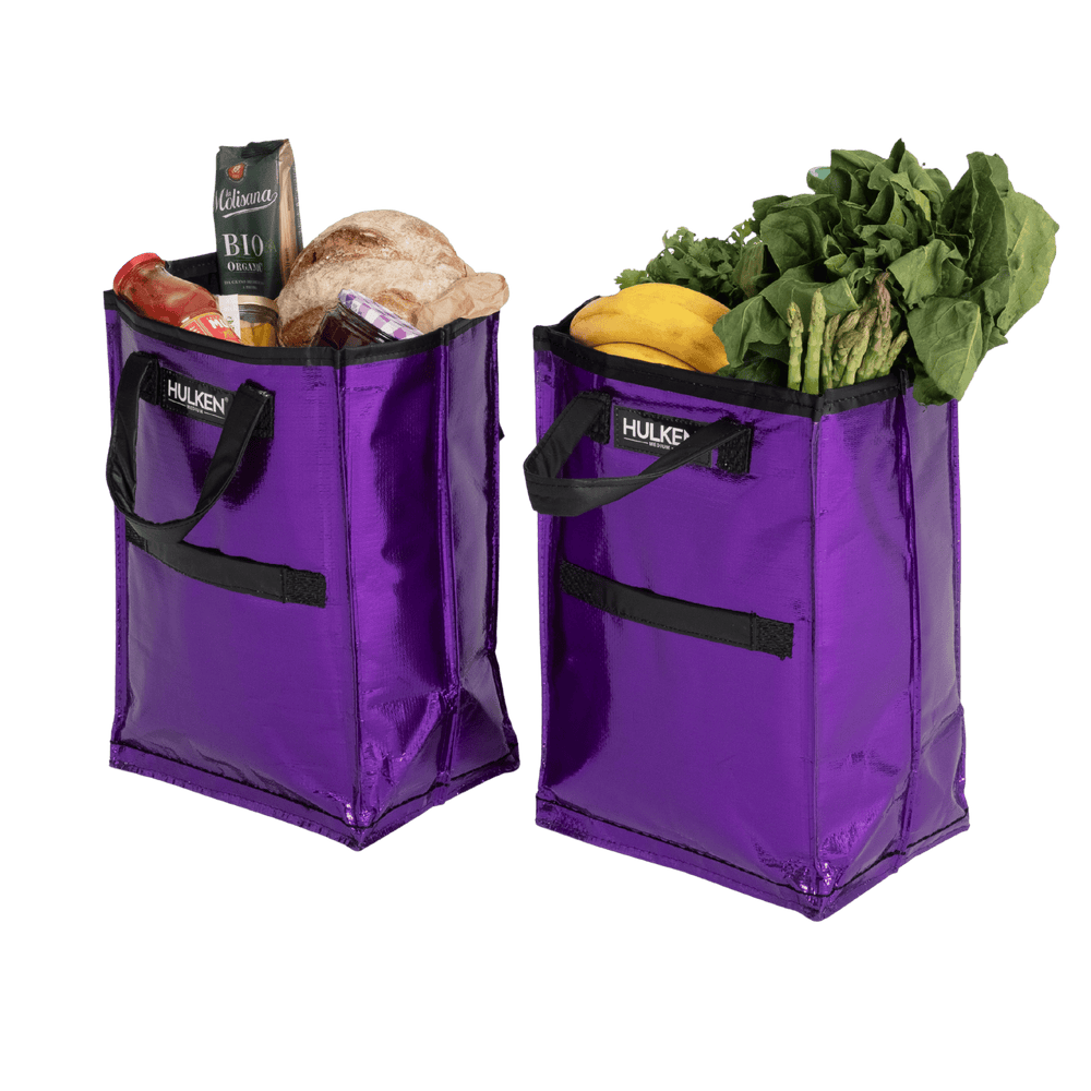 Two purple shopping bags filled with groceries 