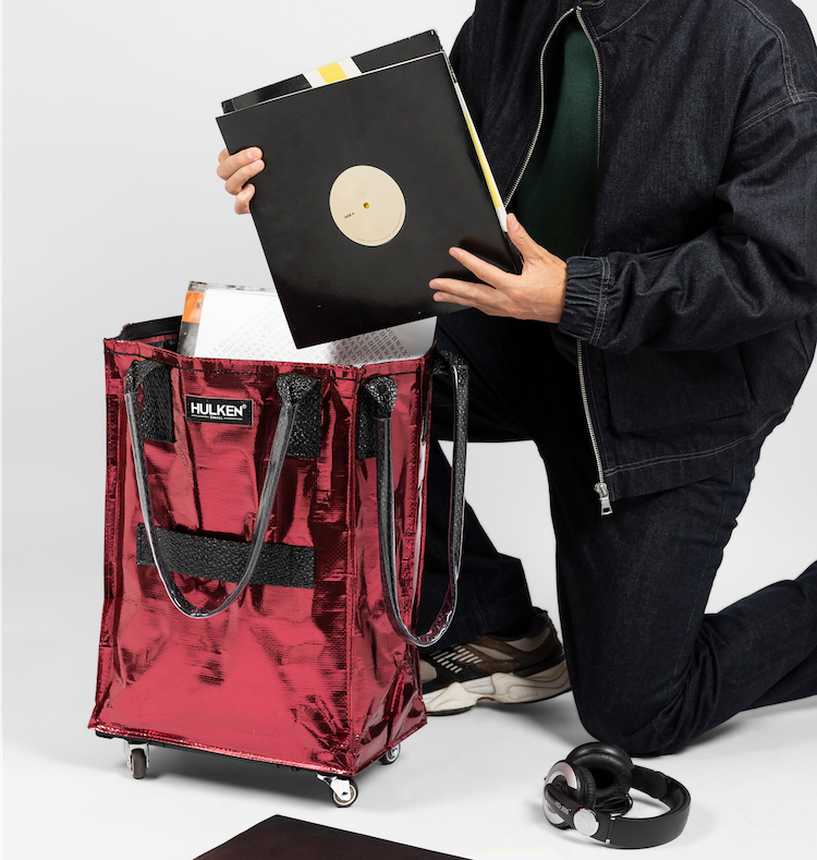 A stylish cosmic red tote bag overflowing with books and notebooks
