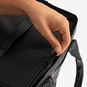 Hand opening a black bag 