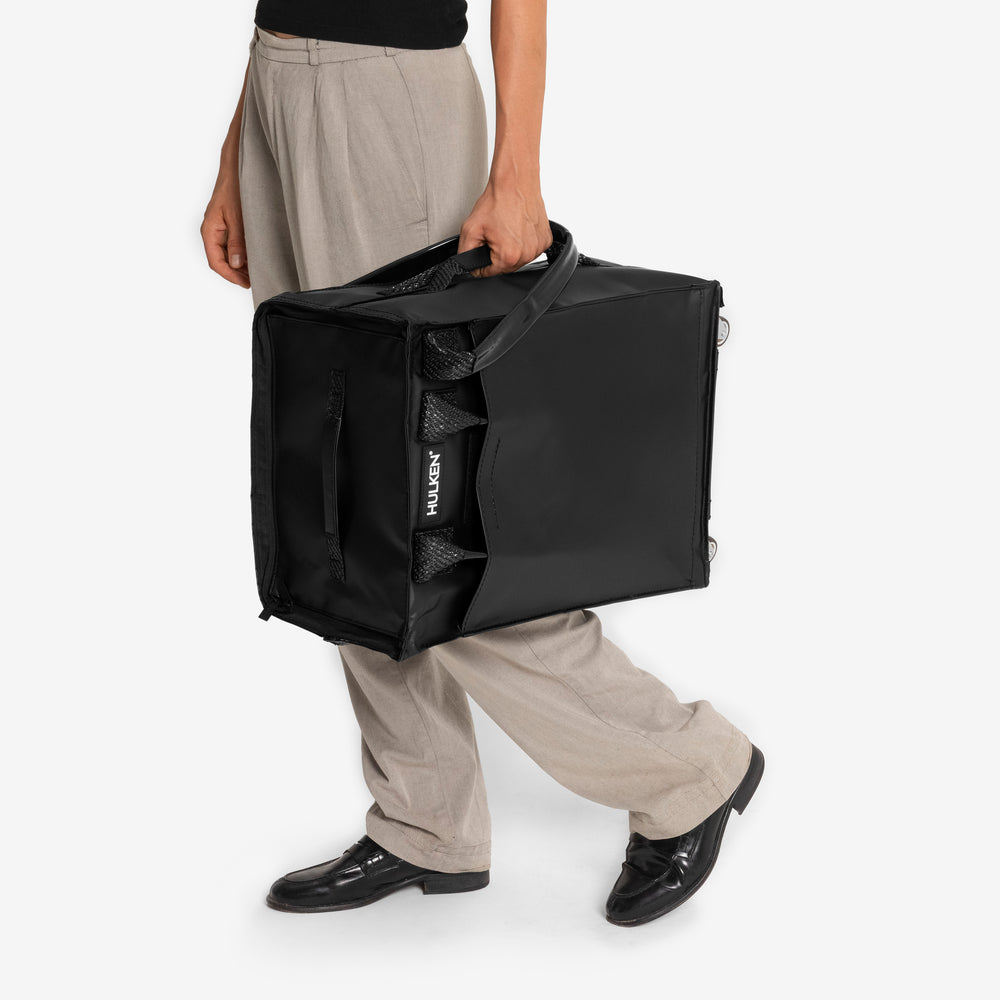 Person holding a black carry-on bag