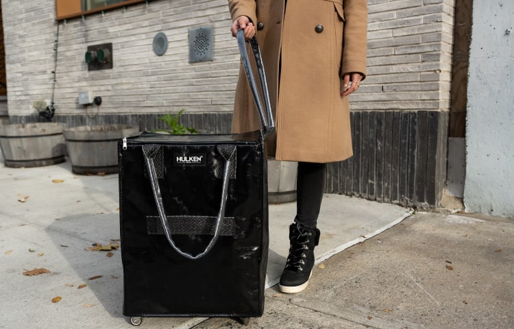 Individual carrying a blue tote bag