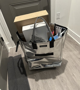 A silver tote bag with boxes inside