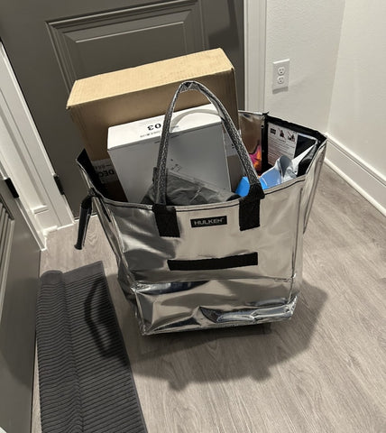 A silver tote bag with boxes inside