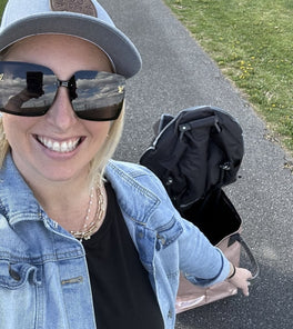 A lady smiles and carries a tote bag